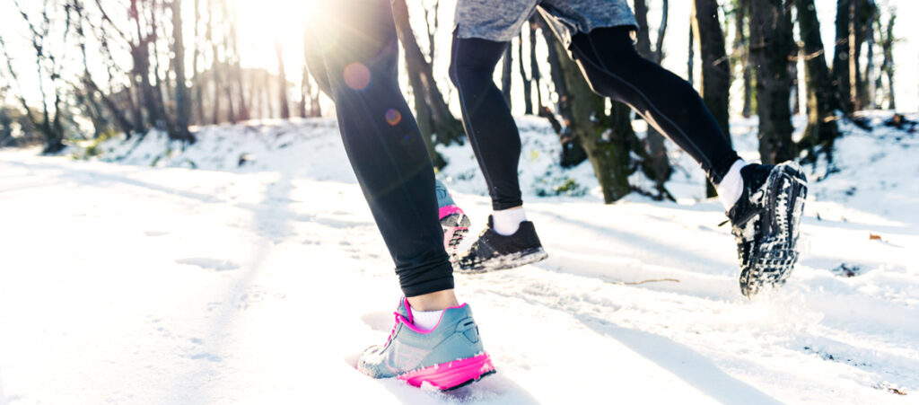 Frau und Mann joggen im Winter