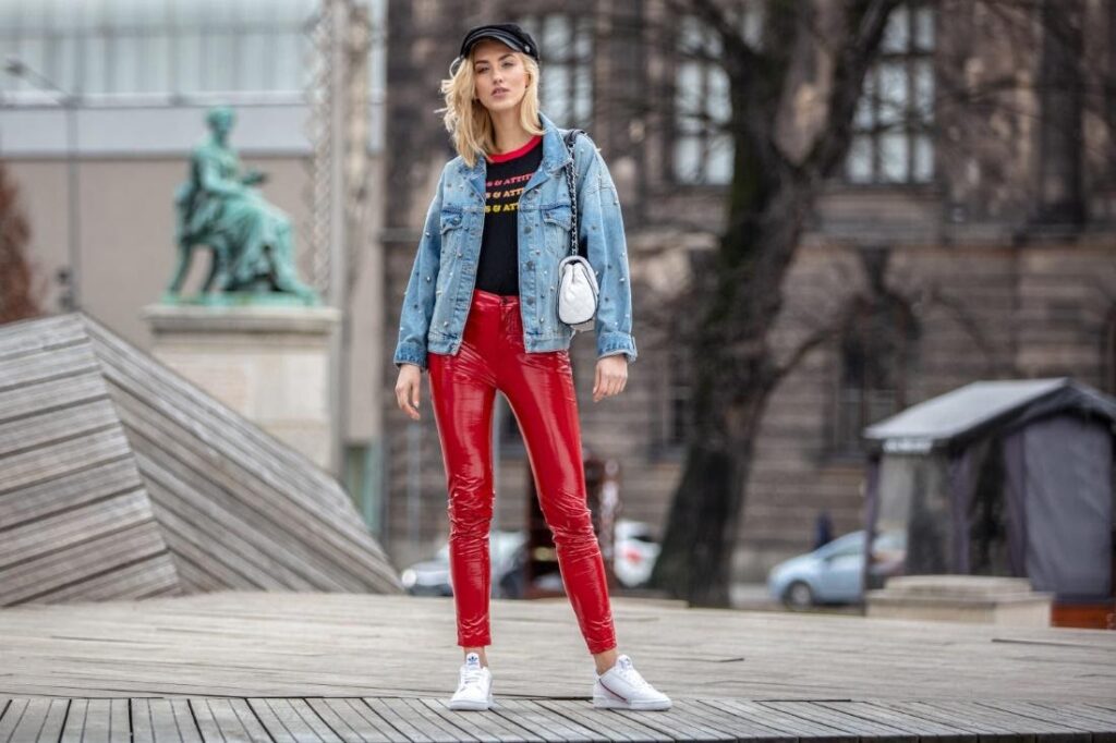 Frau in roten Hosen und einer Jeansjacke