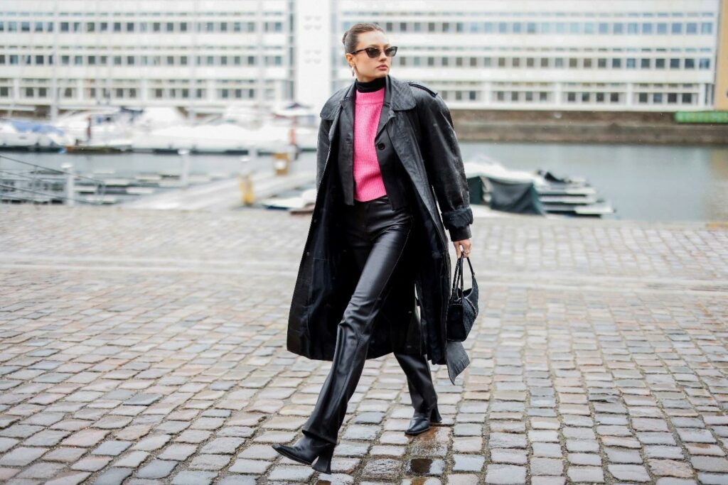 Frau im schwarzen Leder-Total-Look und rosafarbenen Pullover