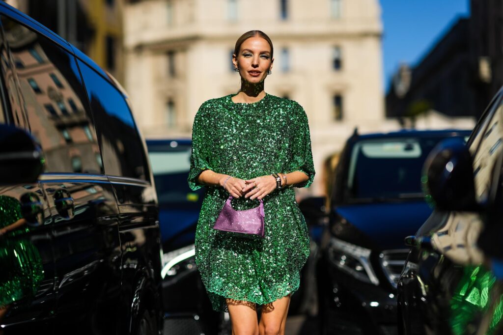 Leonie Hanne in einem grünen Kleid und mit einer violettfarbenen Handtasche