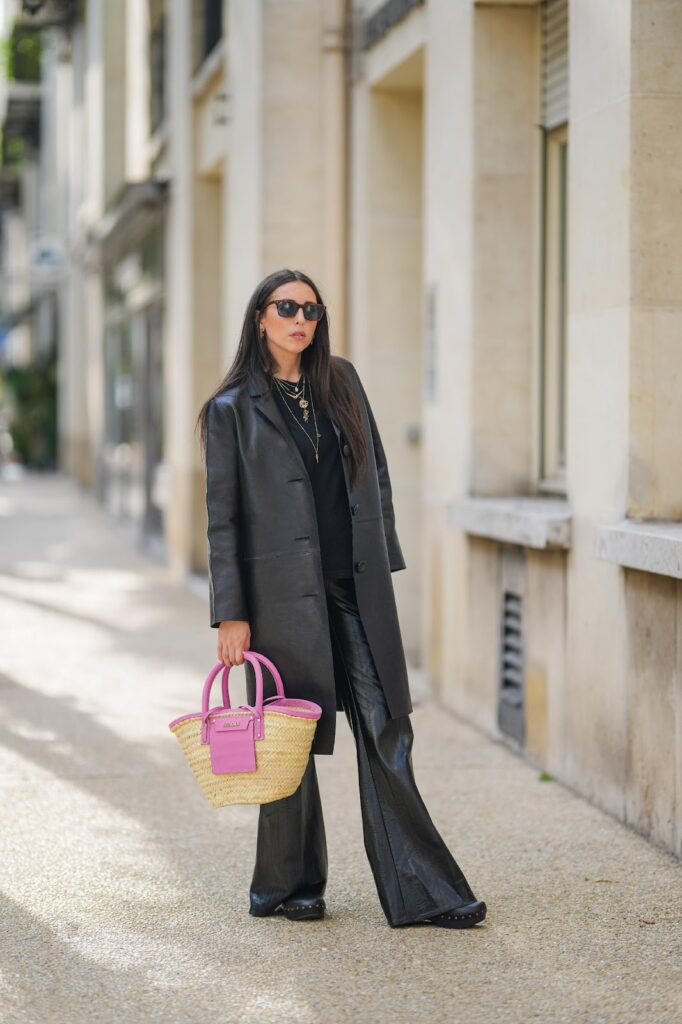 Frau im schwarzen Total-Look mit einer Korbtasche