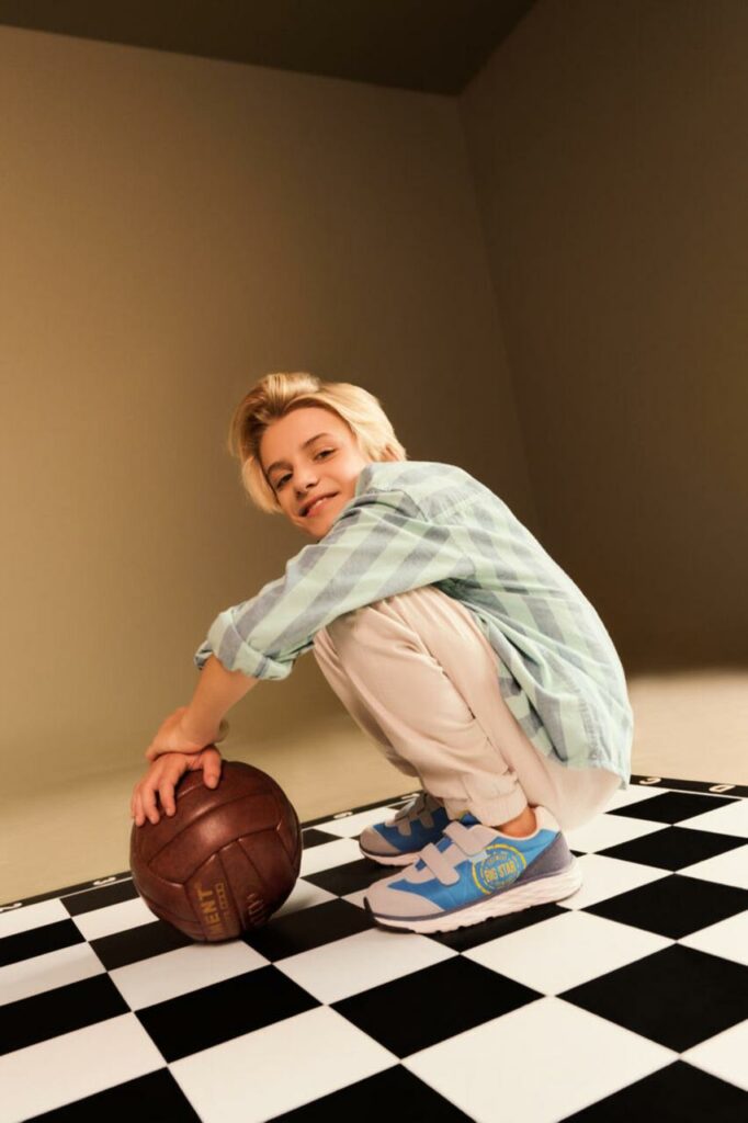 Junge auf einem Schachbrett mit einem Ball