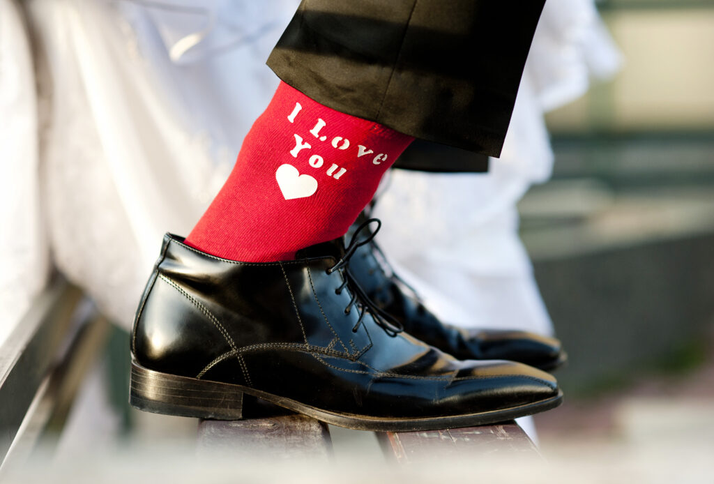 Bräutigam in schwarzen Schuhen und roten Socken