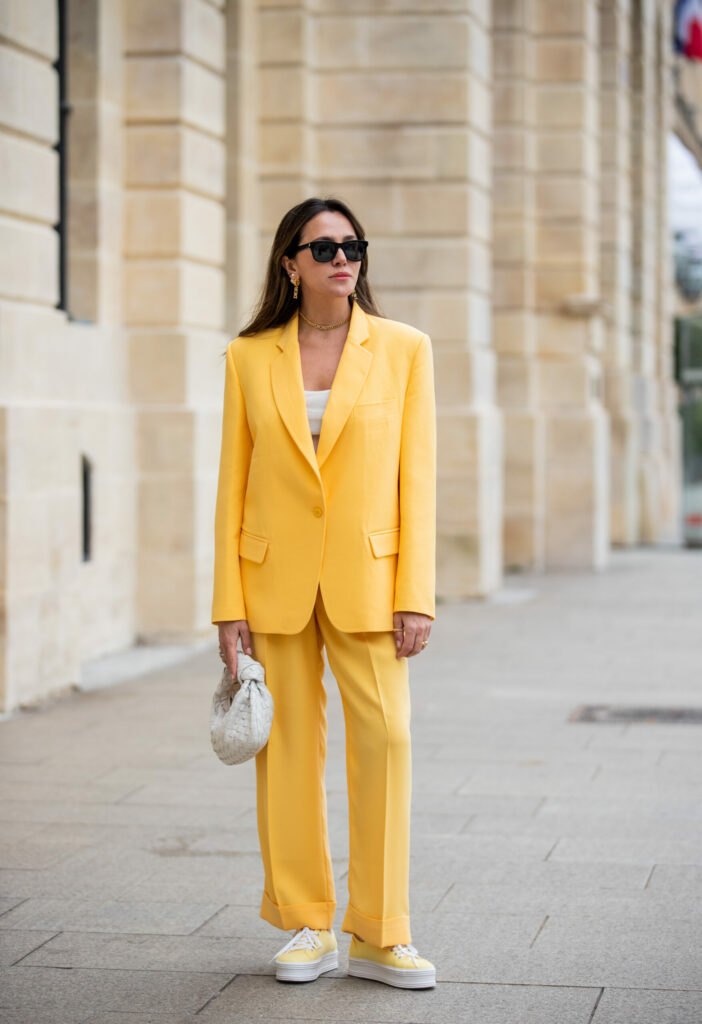 Frau in gelbem Oversize-Kostüm und gelben Plateau-Sneakers