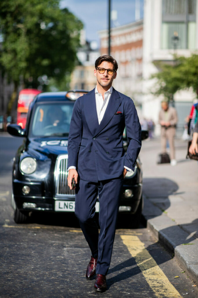 Johannes Huebl im dunkelblauen Anzug wird während der Londoner Modewoche vor Iceberg gesehen