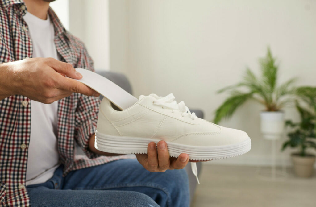 Ein Mann steckt eine neue, saubere Einlage in den Schuh