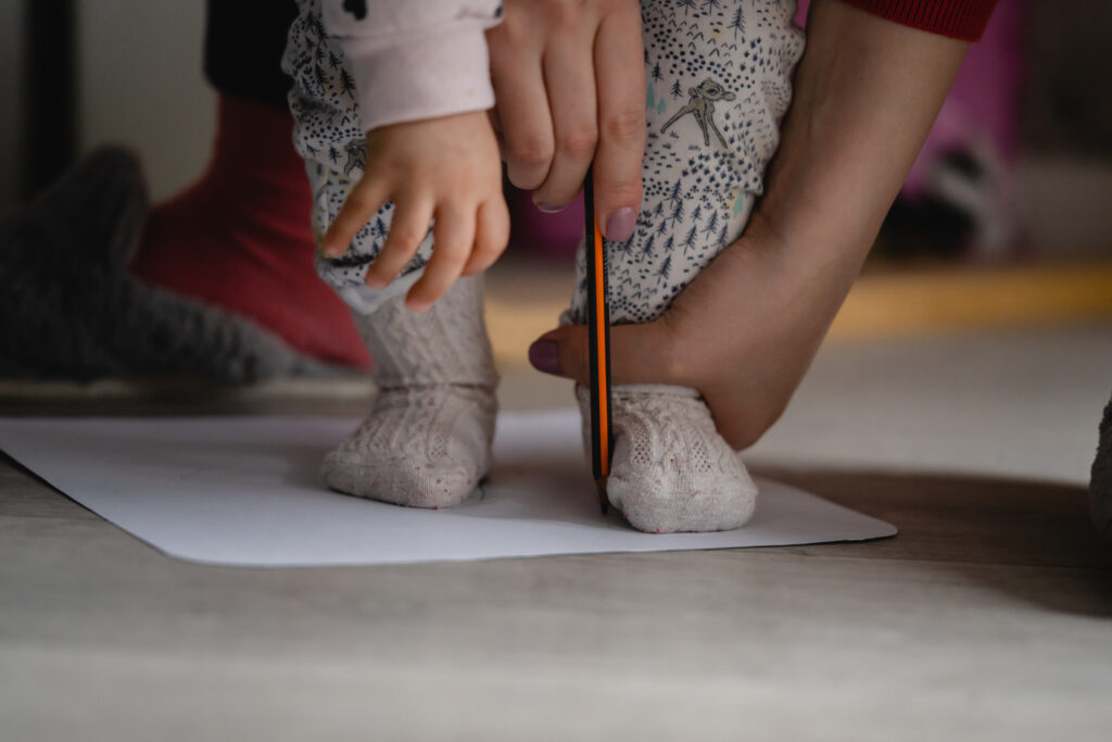 Den Fußumriss auf einem Blatt Papier zu zeichnen, ist eine einfache Möglichkeit, seine Länge genau zu messen