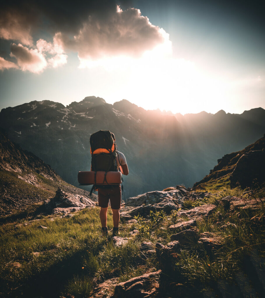 Mann wandert alleine in der atemberaubenden Landschaft der österreichischen Berge bei Sonnenuntergang